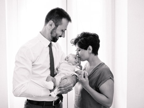 Preparativi battesimo Roma — mamma e papà con il bimbo, momento di tenerezza