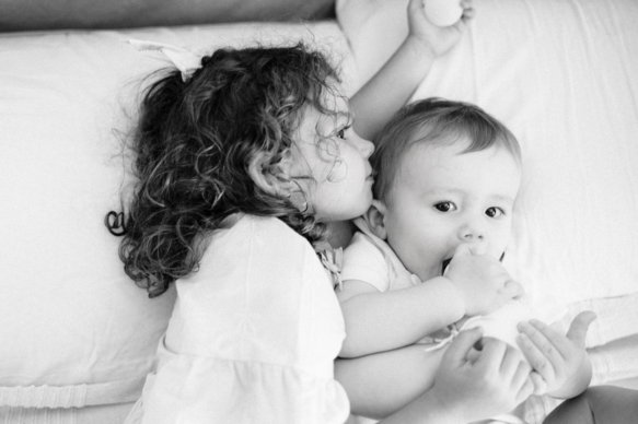 Ricevimento battesimo — sorellina che bacia il fratellino, momento spontaneo durante i festeggiamenti
