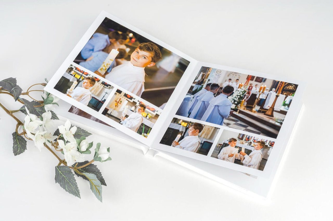 Fotolibro battesimo — dettaglio della doppia pagina con foto della cerimonia, carta di alta qualità con pagine rigide