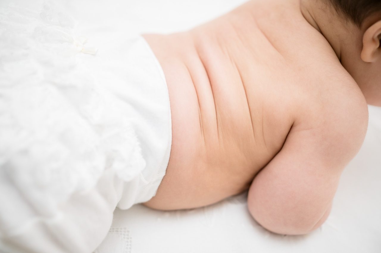 Preparativi battesimo Roma — spalle e schiena della bambina nell'abito bianco di pizzo, scatto reportage