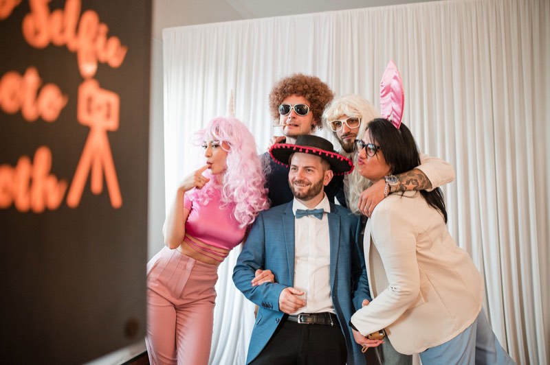Ospiti con costumi e accessori al photo booth matrimonio